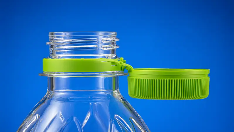 Green tethered bottle cap photographed against a blue background